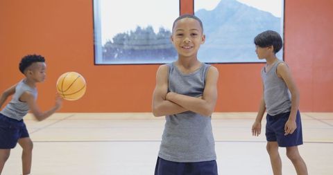Diverse young boys playing basketball in gym