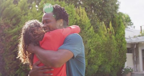 Joyful Biracial Couple Embracing in Sunlit Garden