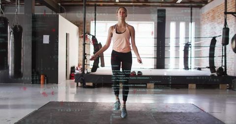 Athletic woman skipping rope in boxing gym