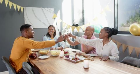 Friends celebrating with toast at birthday gathering