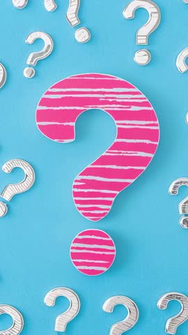 Vertical video showing pink striped question mark surrounded by white question marks on turquoise