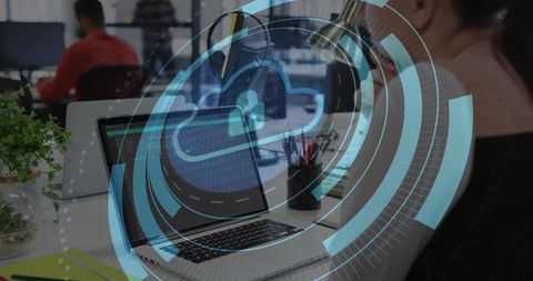 Laptop displaying cloud padlock hologram protecting data at modern open-plan coworking desk