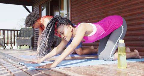 Couple Practicing Yoga Outdoors at Wooden Cabin Retreat