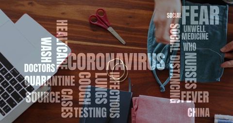 Woman crafting face masks with coronavirus words overlay