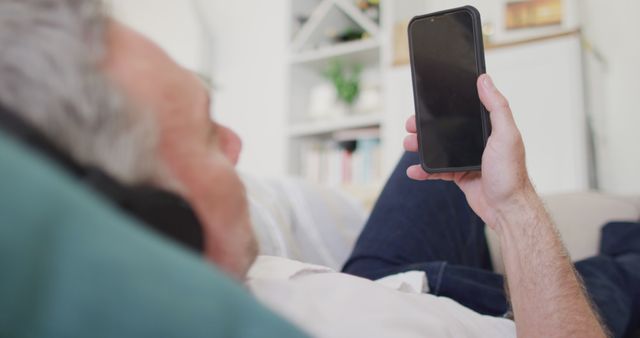 Senior Man Using Smartphone at Home Relaxing on Sofa - Download Free Stock Images Pikwizard.com