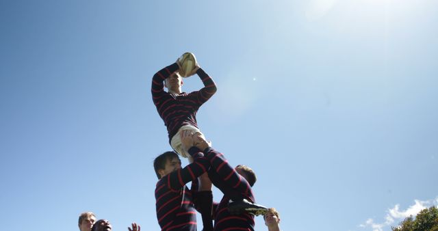 Rugby Players Lifting Teammate for Ball Catch Under Clear Blue Sky - Download Free Stock Images Pikwizard.com