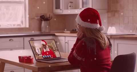 Woman in santa hat video calling family at christmas