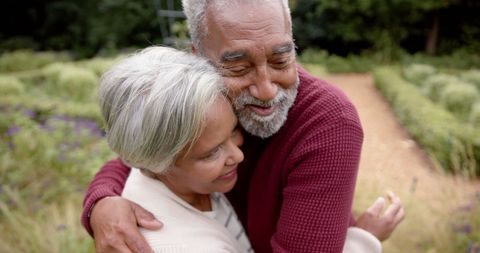 Happy Senior Couple Embracing Outdoors in Lush Garden