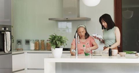 Generations Bonding in Minimalist Kitchen While Clean Dishes