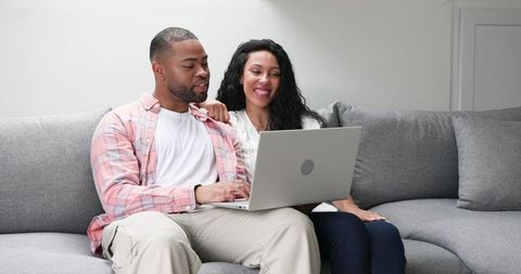 Couple celebrating engagement while video calling at home