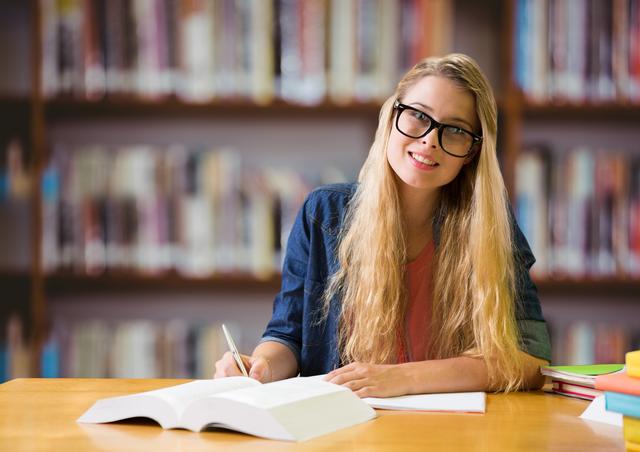 Young woman with spectacles studying in a library, surrounded by books. Ideal for educational content, academic websites, study tips, and learning resources.