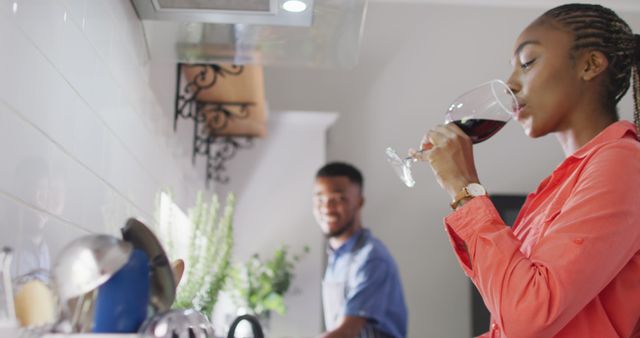 Woman Drinking Wine in Modern Kitchen While Partner Cooks - Download Free Stock Images Pikwizard.com