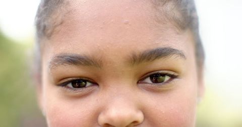 Close-Up of Smiling African American Girl's Brown Eyes Outdoors