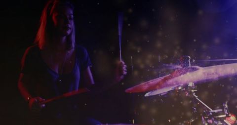 Female drummer performing dramatic stage drum solo