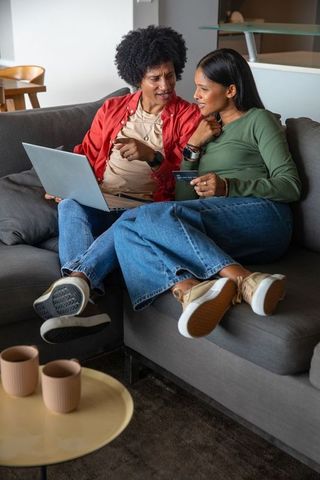 Couple Shopping Online from Cozy Living Room Couch Holding Credit Card