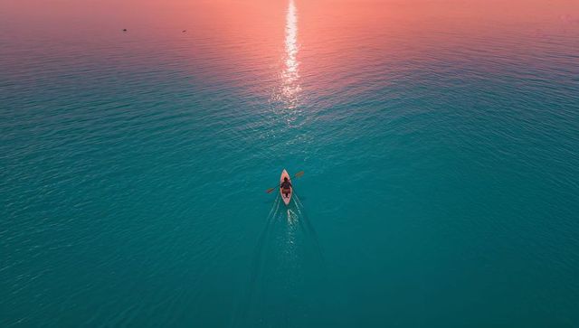 Solo Kayaker Gliding Across Ocean at Sunset With Stunning Reflection