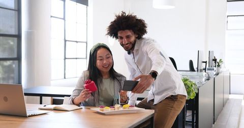 Colleagues Celebrating Birthday with Gift and Cupcakes in Office