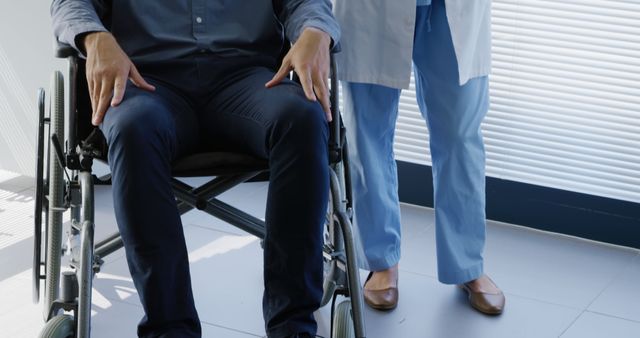 Healthcare Professional Assisting Patient in Wheelchair at Medical Facility - Download Free Stock Images Pikwizard.com