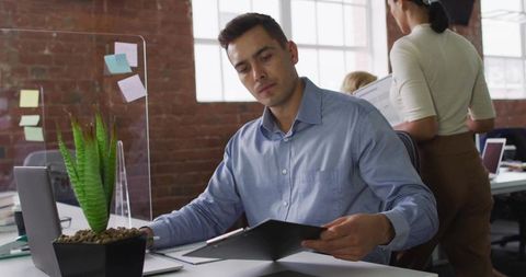 Focused Professional Reviewing Documents at Modern Office Workspace