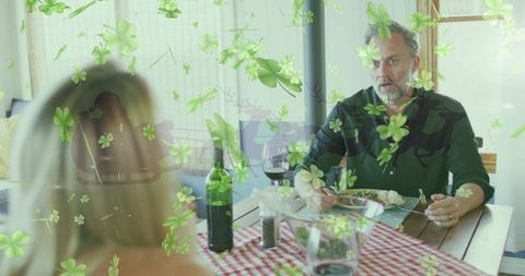 Bearded man eating dinner with green clover overlay, wine bottle and surprised expression
