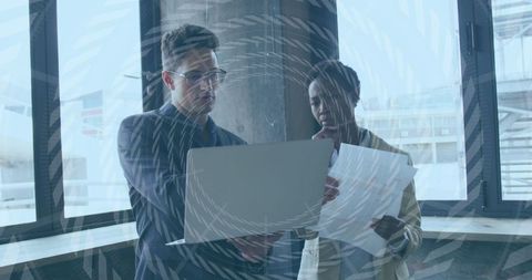 Business Collaboration Analysts Reviewing Documents by Large Window