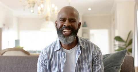 Joyful Mature Man Relaxing on Cozy Sofa at Home