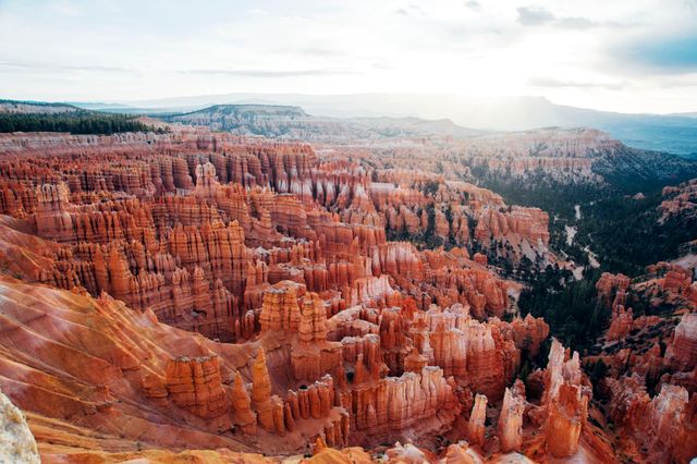 The image captures the breathtaking view of Bryce Canyon during sunrise with vibrant orange rock formations illuminated by the first light of the day. Ideal for travel blogs, tourism promotions, nature magazines, and educational articles about geology or natural wonders.