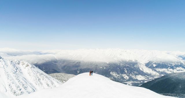 A lone skier stands atop a snowy mountain peak, with copy space. Vast winter landscapes embrace the skier in a moment of serene triumph.