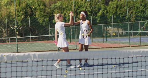 Women Celebrating Sportsmanship on Tennis Court