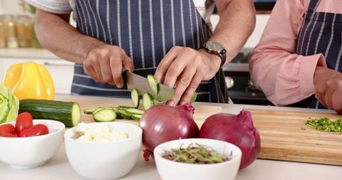 Senior Couple Cooking Together in Home Kitchen with Fresh Ingredients