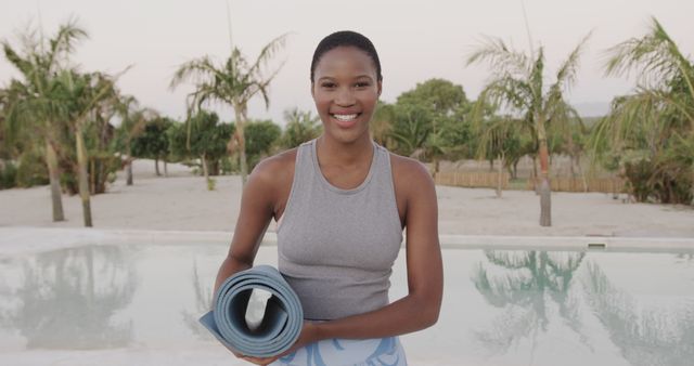 Smiling Woman Holding Yoga Mat by Poolside Outdoors - Download Free Stock Images Pikwizard.com