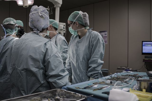 Team of surgeons performing complex operation in a highly sterile environment, demonstrating teamwork and advanced medical procedures. Ideal for use in healthcare materials, medical technology promotions, hospital staff training resources, or articles related to hospital procedures and internal management.