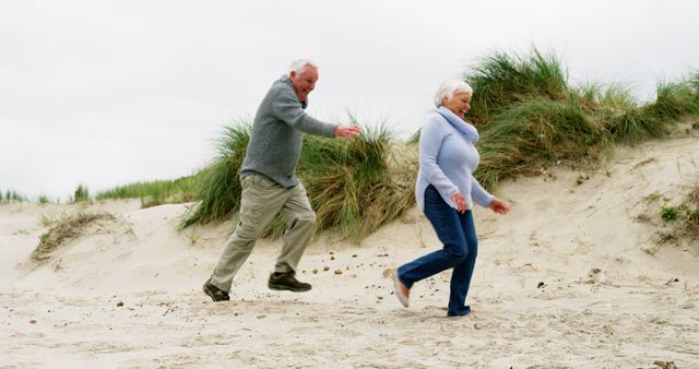 Senior Couple Enjoying Fun on Sandy Beach Dune - Download Free Stock Images Pikwizard.com