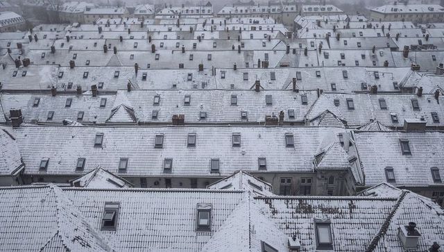 Snow-covered urban rooftops creating repetitive geometric winter pattern from above