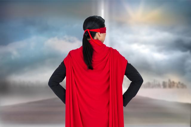 Digital composite of Rear view of business person wearing superhero cape against sky