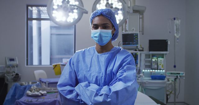 Portrait of asian female surgeon wearing face mask standing in hospital operating theatre. medicine, health and healthcare services during covid 19 coronavirus pandemic.