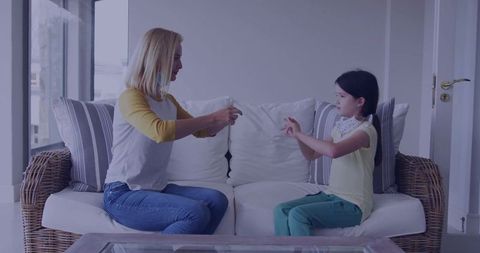 Mother and daughter sharing protective mask at home