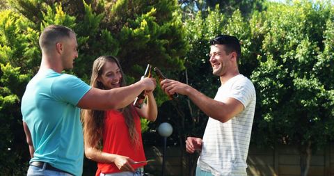 Friends Toasting Drinks at Casual Outdoor Gathering in Garden