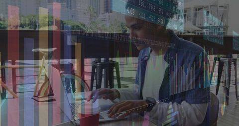 Man Analyzing Financial Data on Laptop with Digital Graphs Overlay