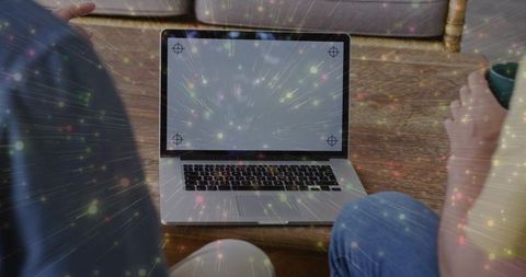 Two men collaborating over laptop with alignment marks and glowing data overlay