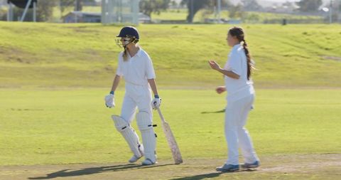 Teenage Female Cricketers Playing on Sunlit Field