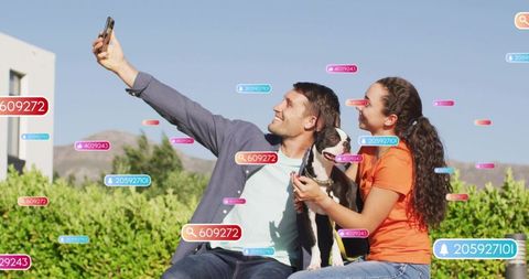 Couple taking selfie with dog surrounded by augmented reality social tags sunny garden