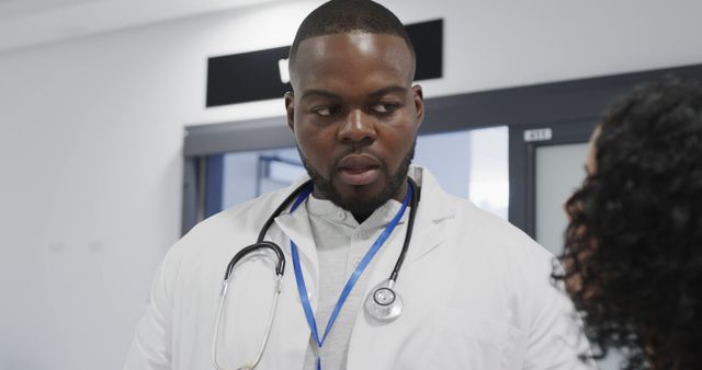 African American doctor consulting with patient in hospital corridor - Download Free Stock Images Pikwizard.com