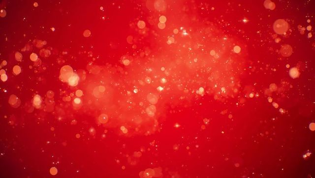 Crimson bokeh glow with sparkling golden particles creating festive depth and warm mood
