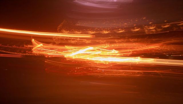 Glowing orange light trails racing across night road long exposure abstract motion blur energy