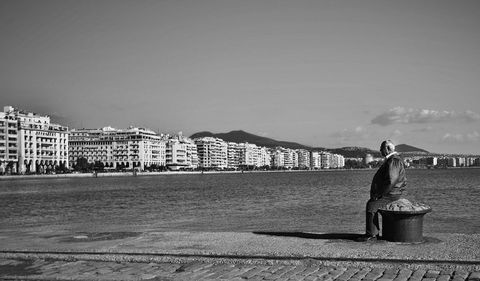 Elderly man reflecting by seaside old town black and white