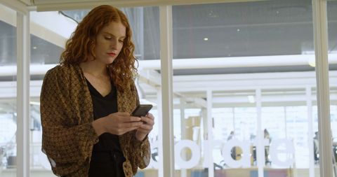 Businesswoman Focused on Mobile Phone in Office - Download Free Stock Images Pikwizard.com
