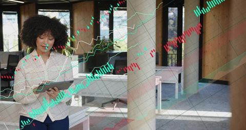 Businesswoman using tablet while analyzing holographic stock charts in modern office