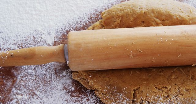 A wooden rolling pin rests on a surface of gingerbread dough sprinkled with flour, with copy space - Download Free Stock Photos Pikwizard.com