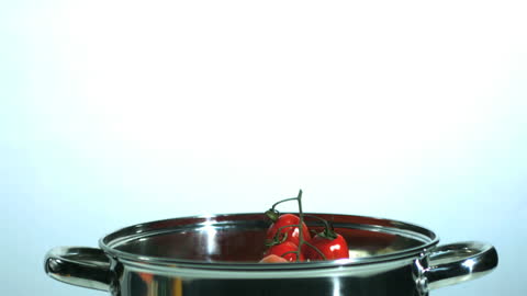 Fresh Tomatoes and Parsnip Falling into Saucepan